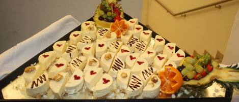 A tray of heart-shaped desserts and a pineapple centerpiece.