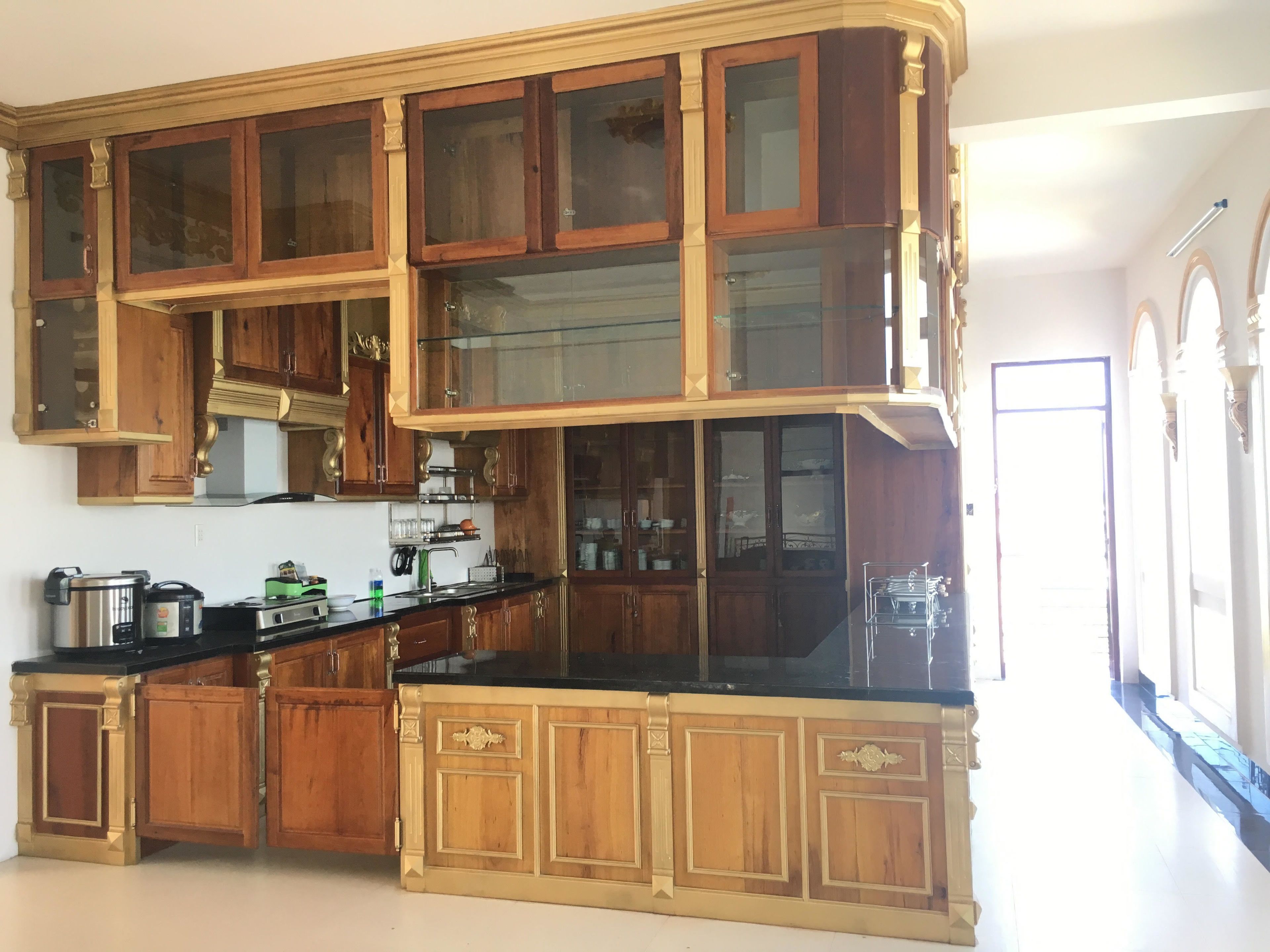 A spacious kitchen with wooden cabinetry and a black countertop.