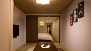 A traditional Japanese-style room with tatami flooring, a low wooden table with two cups, a bed with white bedding, and a sliding door leading to another room. - Yukari Kyoto (Kyoto)