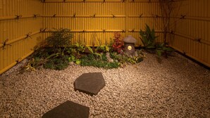 A small indoor garden with a bamboo wall, pebbles, and a few plants. - Yukari Kyoto (Kyoto)