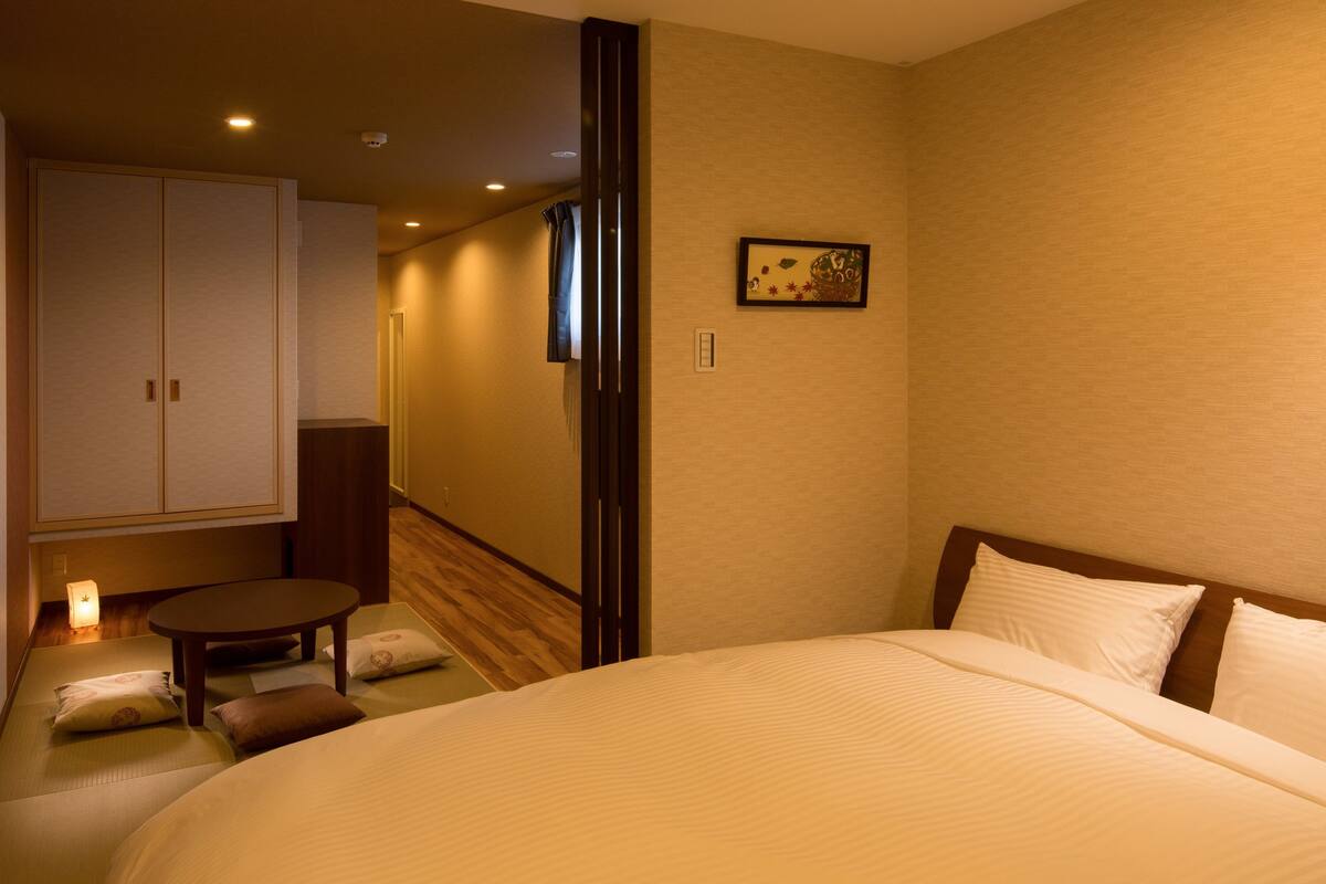 Een hotelkamer met een groot bed, een kleine tafel en een kledingkast.