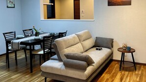 A living room with a sofa, dining table, chairs, and a small side table. - Yukari Kyoto (Kyoto)