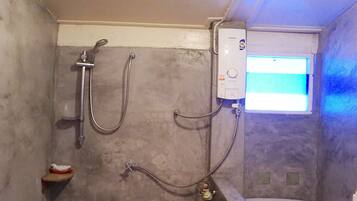 A small, enclosed shower area with a toilet and a water heater.