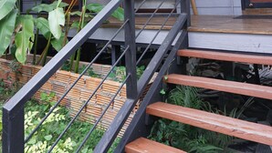 A staircase leading to a wooden door, with a wall-mounted air conditioning unit above. - R-Lampang Guest House (Lampang)