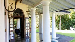 A covered outdoor area with a bench, columns, and hanging lanterns. - Coffee Bungalow Kandy (Kandy)