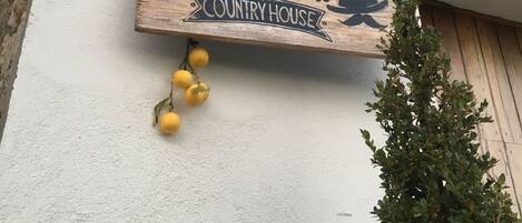 A wooden sign with the text "Don Giacchi COUNTRY HOUSE" hanging from a chain.
