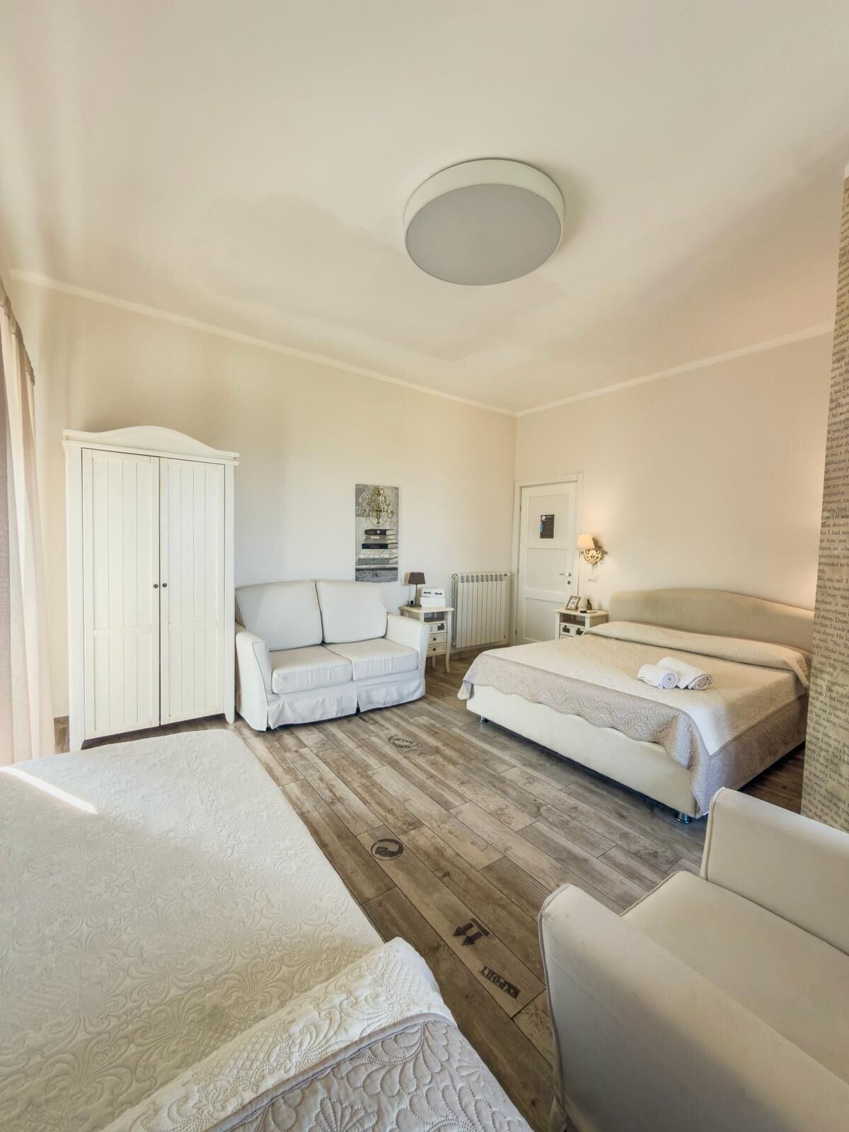 Een hotelkamer met een bed, een slaapbank, een garderobe en een radiator.