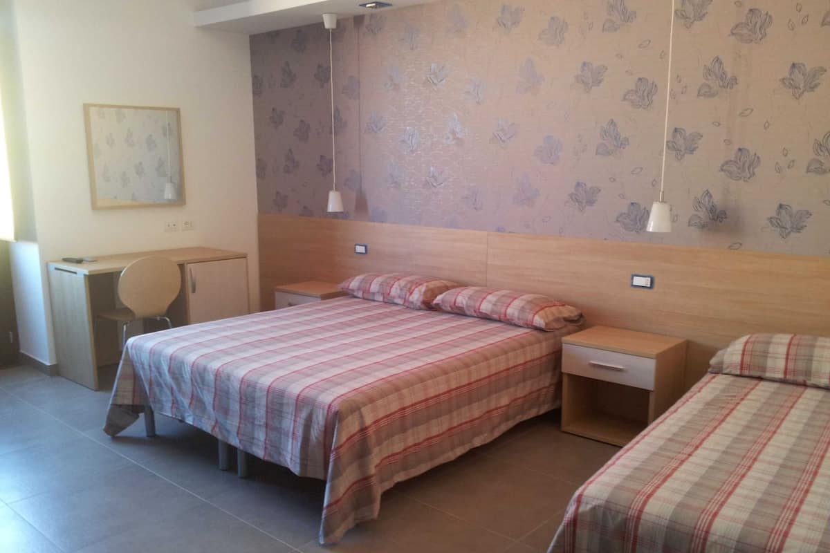 Une chambre avec deux lits, un bureau et une chaise.