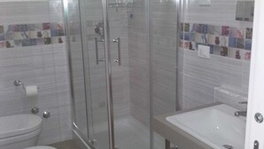 Ein Badezimmer mit Duschkabine, Toilette und Waschbecken.