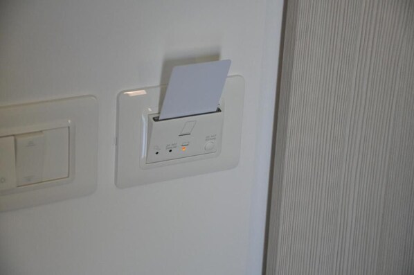 Pareda com entrada para cartão, interruptor de luz e tomada elétrica.