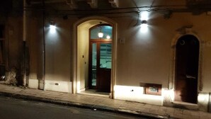 Ein Gebäude mit Bogenportal, kleinem Fenster und einem Balkon.