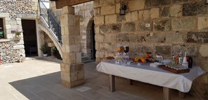 An outdoor buffet setup with a stone wall backdrop, a staircase, and potted plants. - Salento Ada's House (Melendugno)