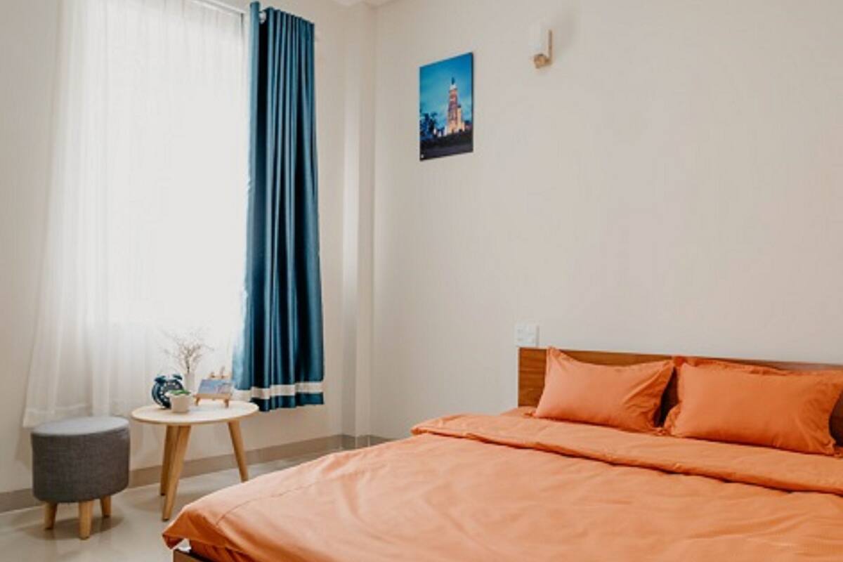 A bedroom with a wooden bed, a small round table, and a nightstand.