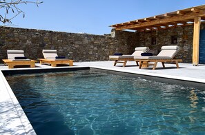 A poolside area with lounge chairs and a pergola.