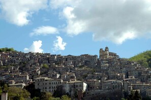 Un pueblo en una ladera densamente poblada con edificios históricos, una destacada torre de iglesia y una mezcla de estructuras residenciales y comerciales.