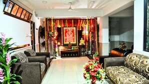 Sala de estar con sofás, una mesa de centro y un altar decorativo.