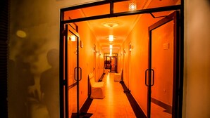 Un pasillo de hotel con un cálido resplandor anaranjado.
