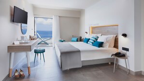 Una habitación de hotel moderna con cama, escritorio, silla y televisor.