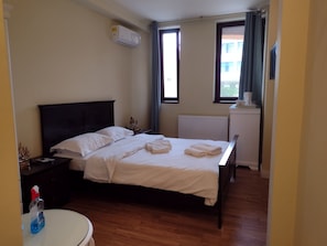 A hotel room with a bed, bedside table, and a window with curtains. - Vila Adry's (Constanta)