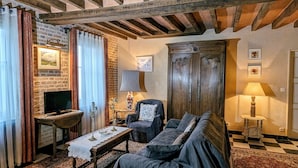 Una sala de estar acogedora con chimenea, un sofá, un televisor y un aparador de madera.