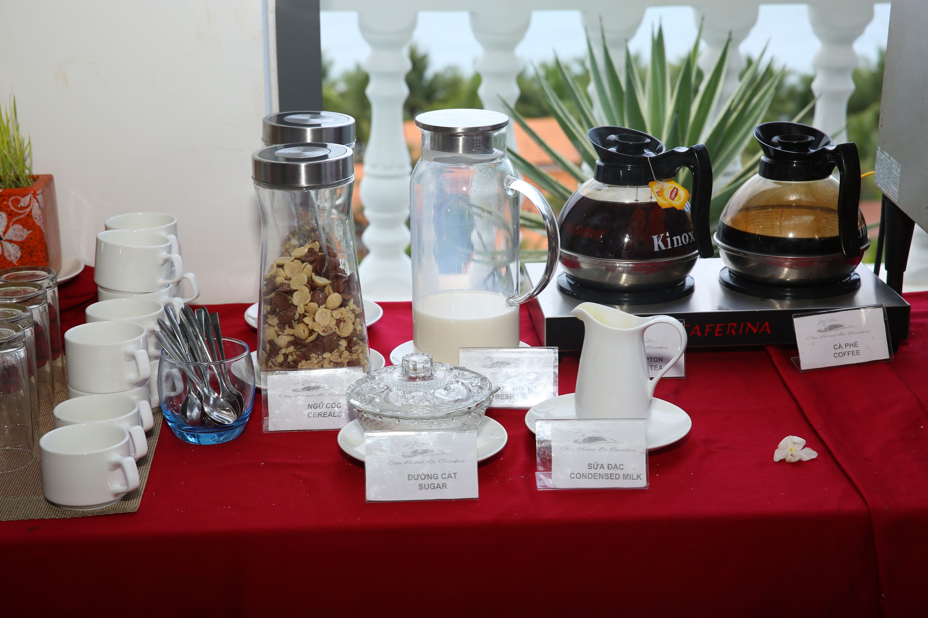 Een ontbijtbuffet met diverse etens- en drinkwaren, waaronder koffie en gecondenseerde melk.