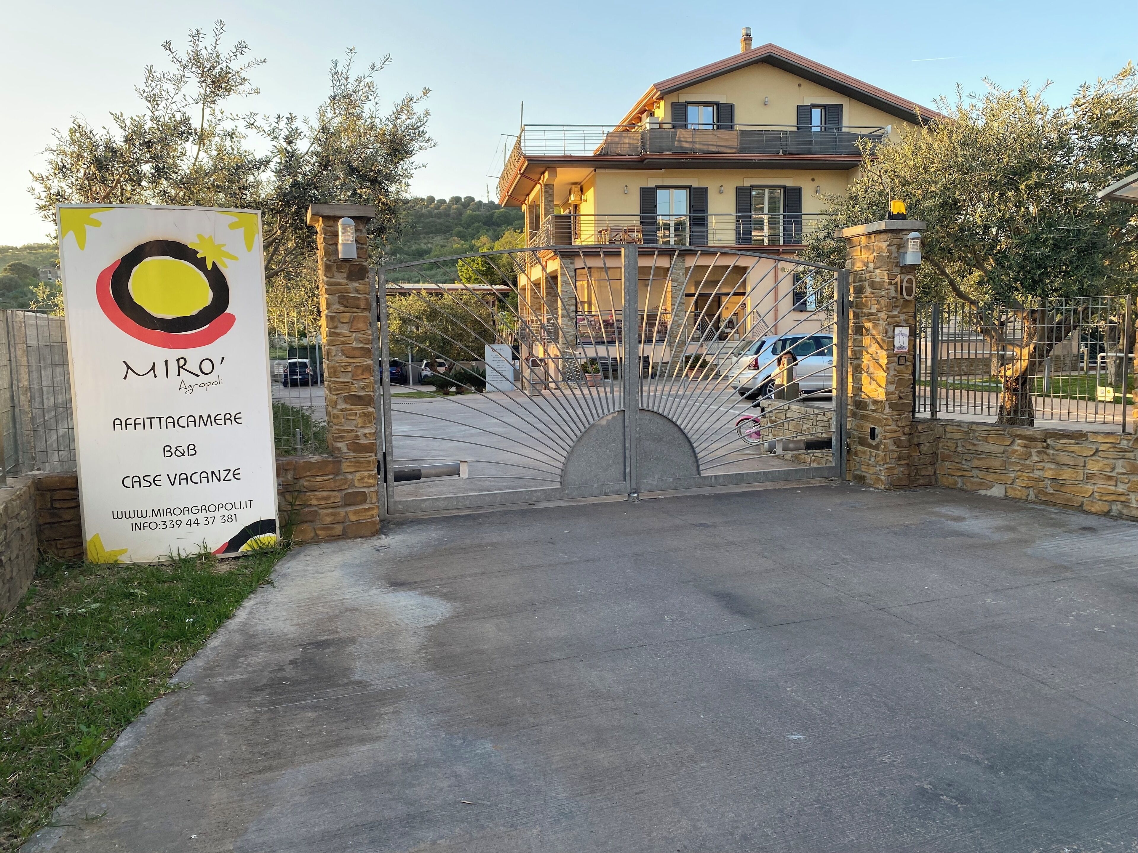 Ein verschlossenes Tor zu einem Grundstück mit einem Schild, das 'MIRO' Agropoli bewirbt, eine Pension mit freien Zimmern.