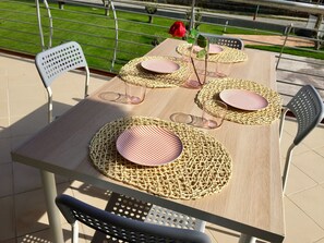 An outdoor dining area with a wooden table set for four, surrounded by metal chairs. - Miro' Agropoli (Agropoli)