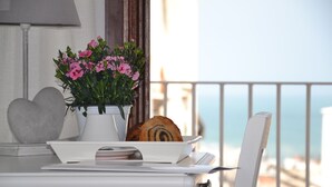 A table with a white vase of pink flowers, a plate with a pastry, and a heart-shaped object. - B&B Cuore di Vieste (Vieste)