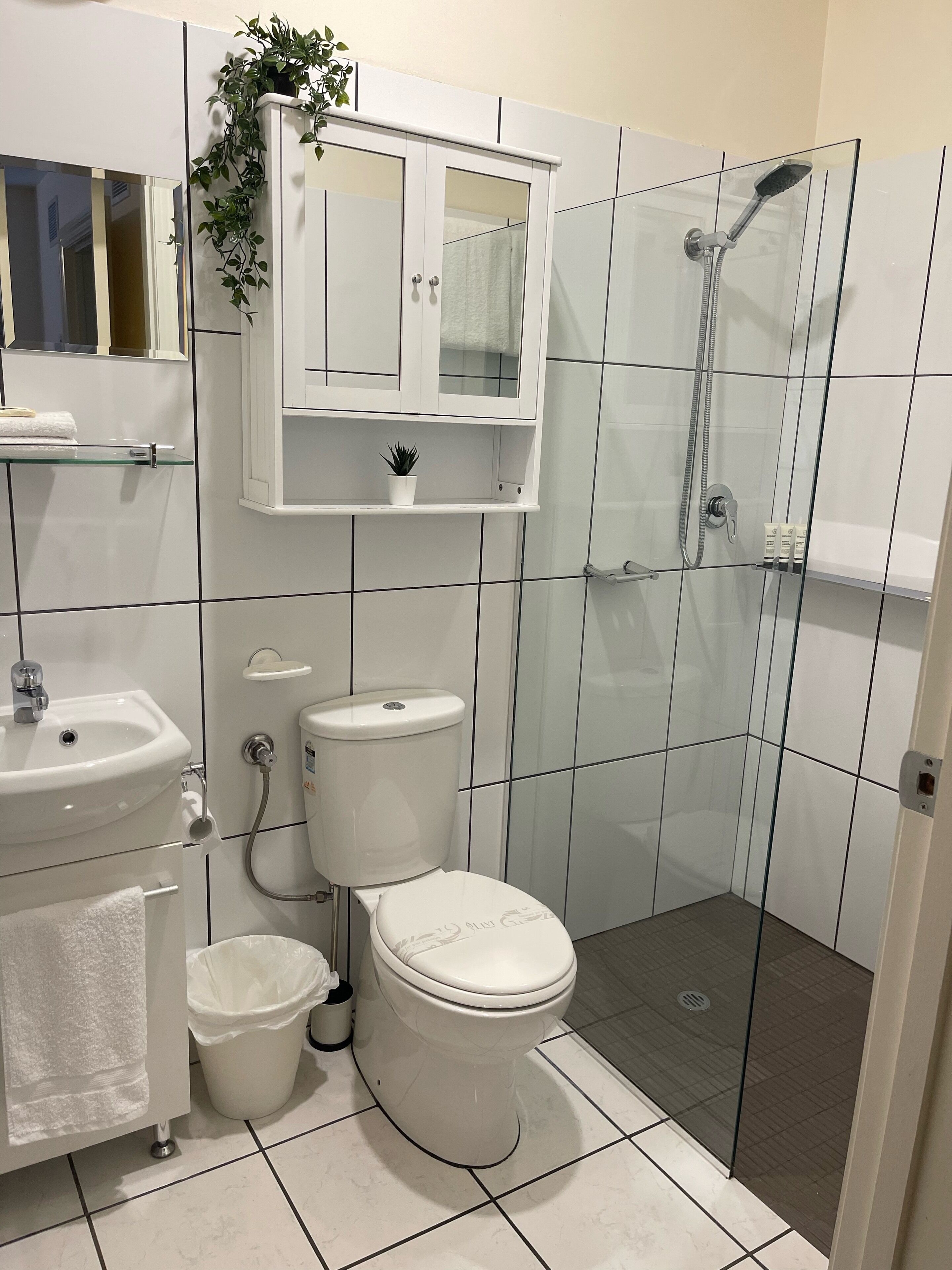 A bathroom with a toilet, sink, and shower.