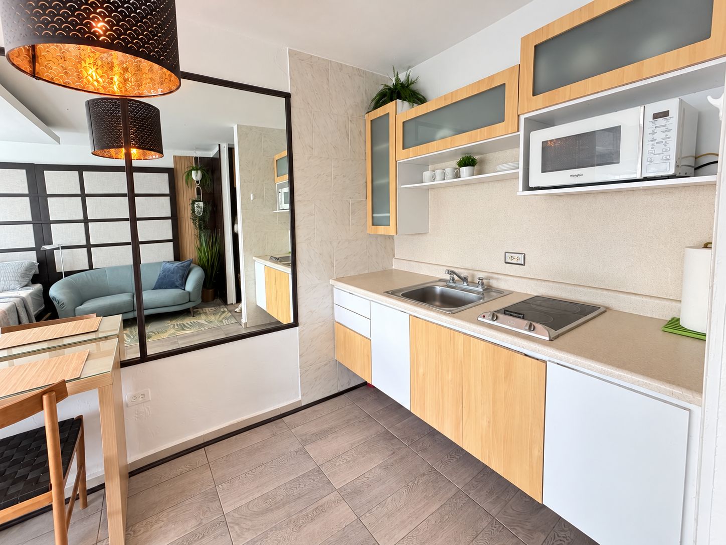 A compact kitchen with a built-in microwave, a sink, and a stove.