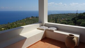 Un balcon avec vue sur la mer et un sol en terre cuite.