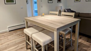 En matplats med ett träbord och bänkar, en soffa och inramade tavlor på väggarna.