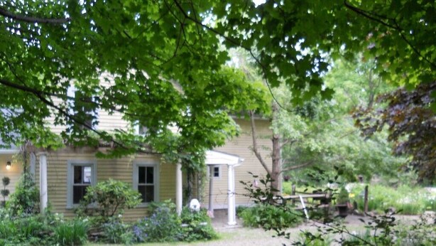 A house with a front yard, a wooden fence, and a garden area. - Charming, river front compound  (Bantam)
