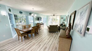 A spacious living room with a dining area, wooden flooring, and light blue walls. - Perfect for a Beach Getaway, Great View and Near the Pool, B2613A (Cape Haze)