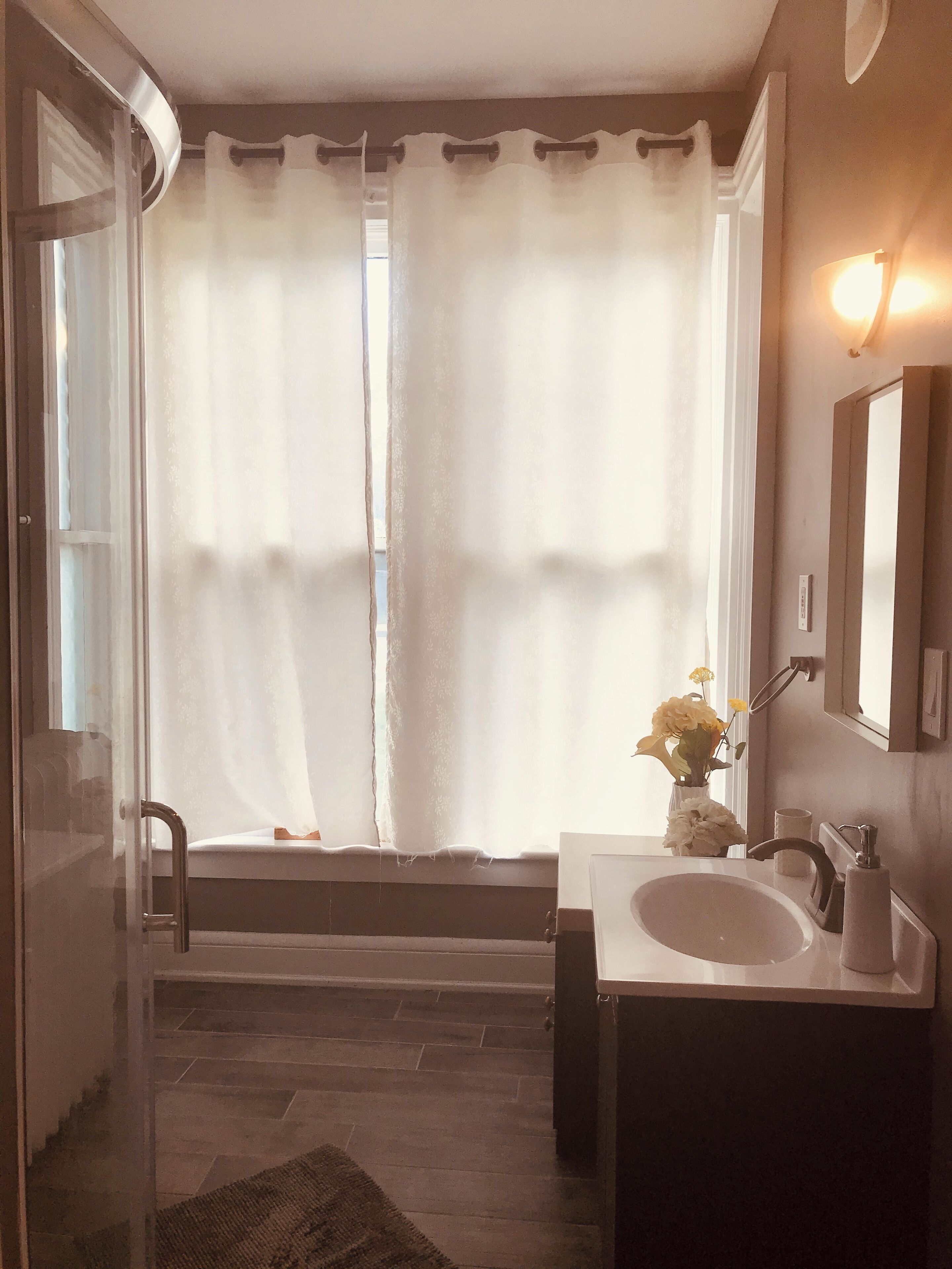 A bathroom with a bathtub, a sink, and a mirror.