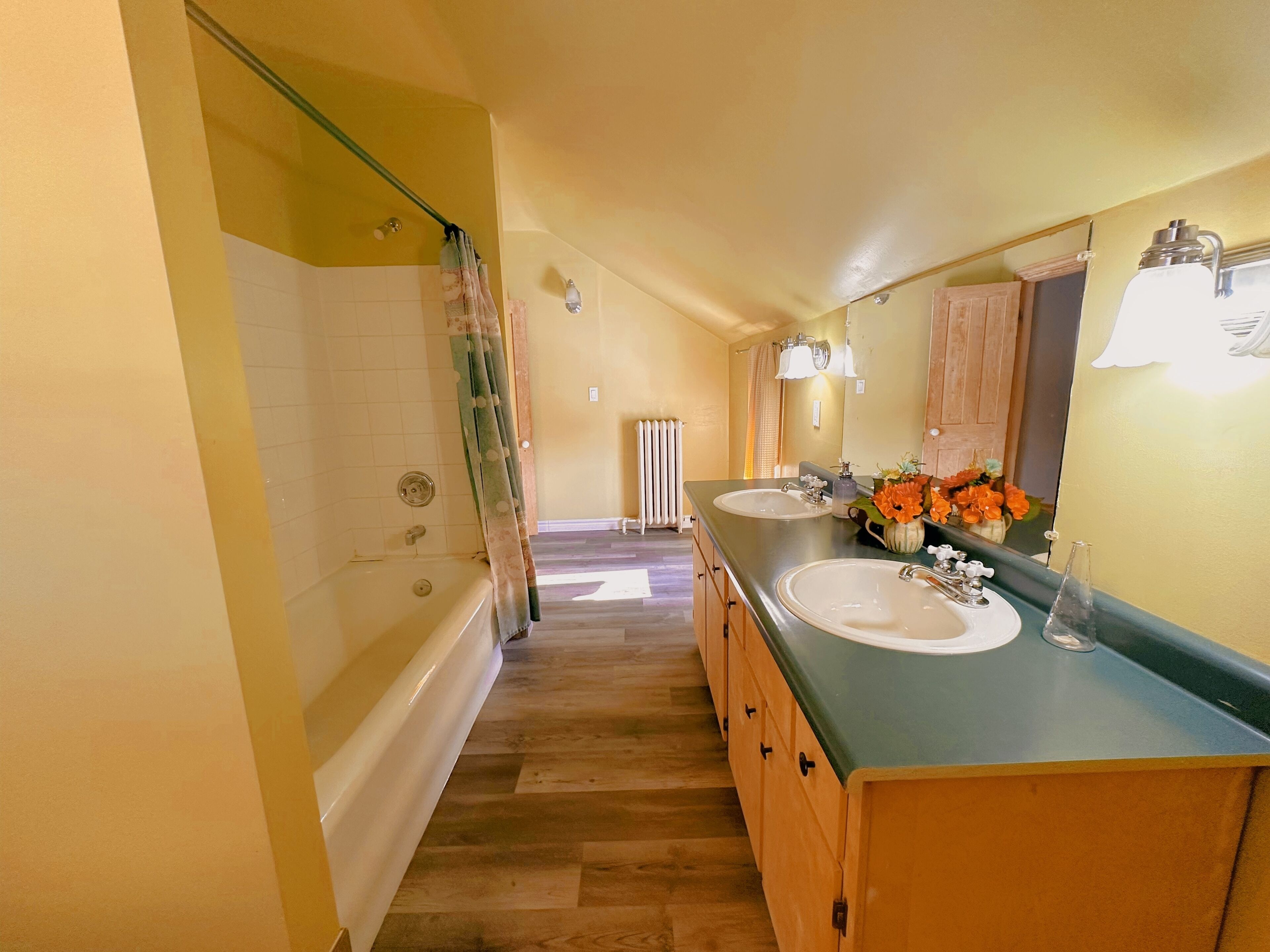 A bathroom with two sinks, a shower, and a large mirror.