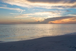 Enjoy a serene beach experience with a wide, sandy shoreline and a calm sea.