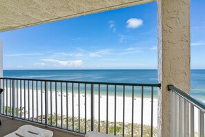 Ein Balkon mit Blick auf Strand und Meer.