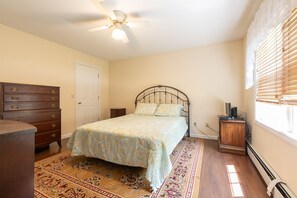 A bedroom with a bed, dresser, ceiling fan, and a window with blinds. - Relax by the sea! 4 bedroom retreat in Bonnet Shores. Central Air sleeps 8A & 2C (Narragansett)