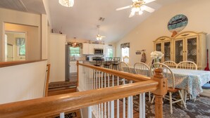 A spacious kitchen with white cabinets, a microwave, and a dining area with a table and chairs. - Relax by the sea! 4 bedroom retreat in Bonnet Shores. Central Air sleeps 8A & 2C (Narragansett)