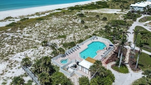 An aerial view of a resort with a swimming pool, lounge chairs, and a beach. - Enjoy a Beautiful Gulf Sunset from the Screened Porch on Resort Villa A3221B (Cape Haze)