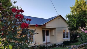 A single-story house with a beige exterior, a dark roof, and a front door. - Ideal for families and groups (Buchan)