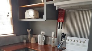 A kitchen with a white stove, wooden countertop, and grey cabinets. - Ideal for families and groups (Buchan)