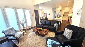 A living room with a sofa, armchairs, a coffee table, and a dining area with a table and chairs. - Austin Compound 1 Block off Trendy South Congress, Perfect for Groups Traveling Together! (Austin)