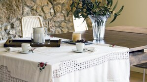 A dining table set with white tablecloth, a vase with flowers, and a candle. - Ca l'Helena. Enjoy the Penedès, the wine region of Barcelona (Castellet i la Gornal)