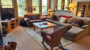 A cozy living room with a television, two sofas, a coffee table, and a rocking chair. - Snowcreek Resort Vacation Rental 838 (Mammoth Lakes)