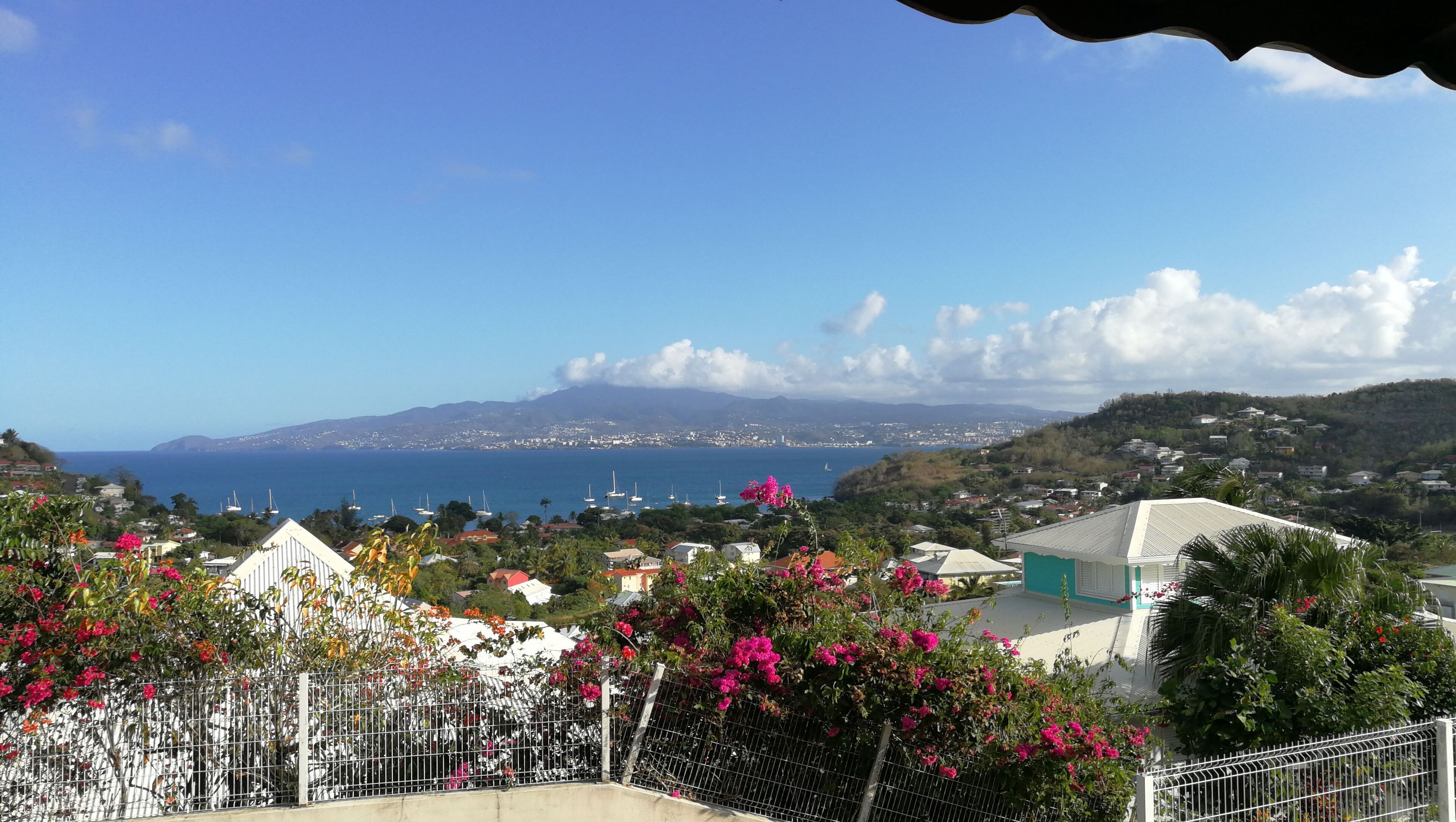 A coastal town with houses and a view of the sea and mountains.