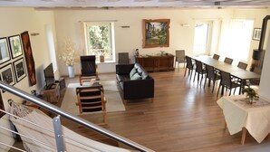 A spacious living area with a sofa, dining table, and chairs, a hammock, and a painting on the wall. - an oasis of relaxation in the quiet of Valpantena (Grezzana, Verona)