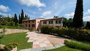 A two-story house with a stone wall and a paved pathway leading to the entrance. - an oasis of relaxation in the quiet of Valpantena (Grezzana, Verona)