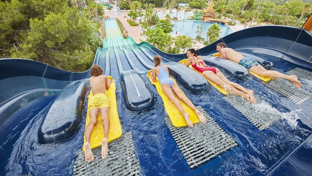 A water slide with multiple lanes and people lying on mats. - Alexis plus Zeus Salou 0141 (Salou)